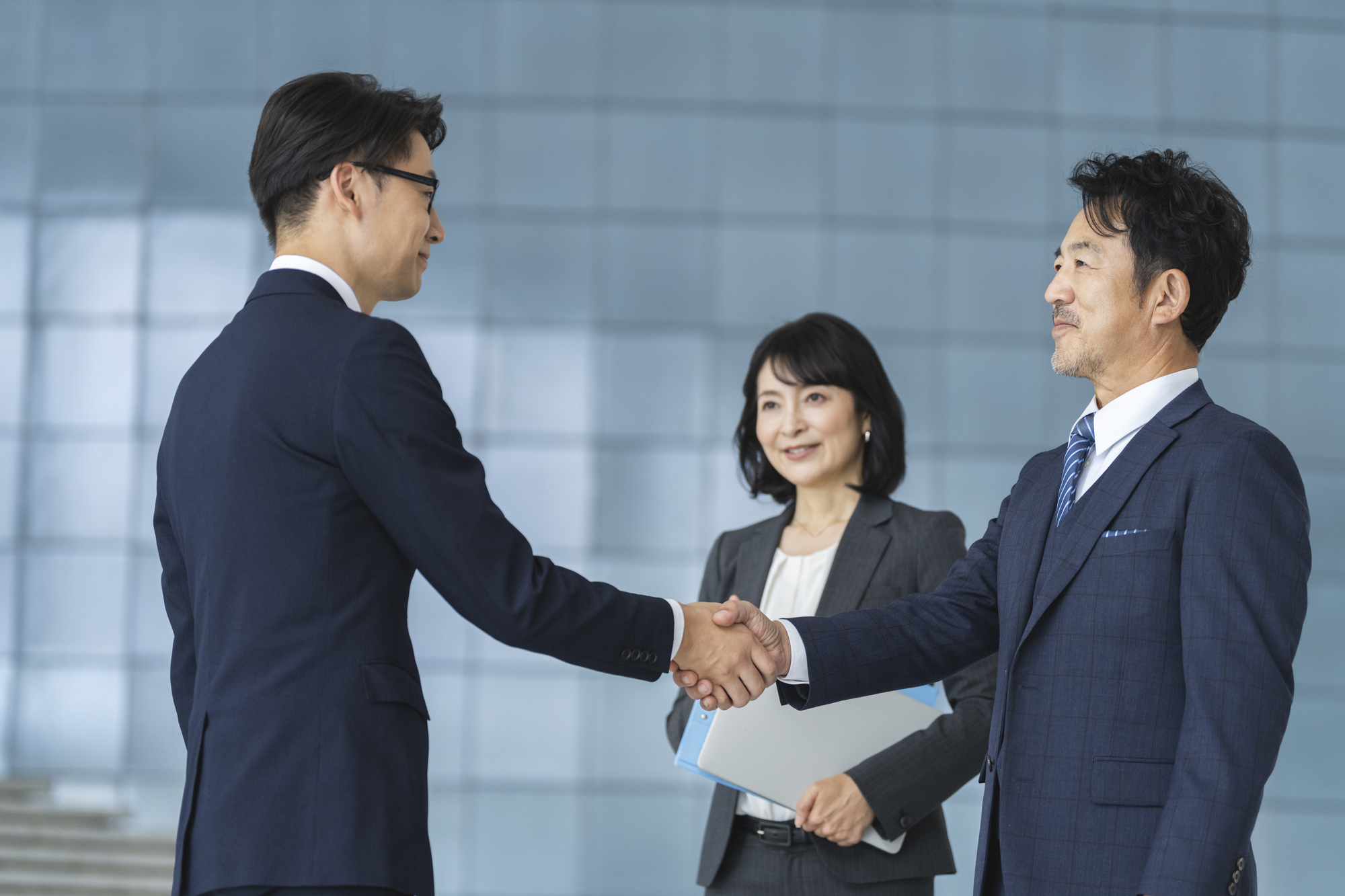 「中国の取引先とメールや商談をする際、相手をどう呼ぶのが正解だろう」と悩んでいませんか。辞書を引くと「客户 kèhù」や「合作伙伴 hézuò huǒbàn」など様々な単語が出てくるため、実務でどれを使うべきか迷うこともあると思います。 中国語のビジネスコミュニケーションでは、相手との関係に合った言葉を選ぶことが、良好な関係づくりにつながります。 本記事では、顧客・パートナー・商社など、状況に応じた「取引先」の中国語表現の使い分けと、仕事で使いやすい実務フレーズを紹介します。 これまで中国企業とやり取りを行っていた経験をもとに、現場で役立つ表現をまとめました。この記事を読めば、取引先とのやり取りで使いやすい表現が分かり、実務で迷いにくくなります。  取引先の中国語表現 日本語では「取引先」と一言で表しますが、中国語では相手との関係によって表現が変わります。 まずは実務でよく使う言葉の違いを確認し、そのまま使えるフレーズも見ていきましょう。  相手の立場によって単語を使い分ける  中国語では、日本語の「取引先」をそのまま一つの単語で表さず、相手との関係によって言葉を使い分けることが一般的です。  中国語 ピンイン 意味 関係性供应商gōngyìngshāng仕入先・サプライヤー部品や材料などを提供する会社客户kèhù顧客・取引先商品やサービスを購入する相手合作伙伴hézuò huǒbàn協力会社・パートナー一緒に仕事やプロジェクトを進める相手 相手との関係に合った表現を使うことは、仕事を円滑に進めることにもつながります。  実務で使えるフレーズ  供应商已经确认交期了。 Gōngyìngshāng yǐjīng quèrèn jiāoqī le. （仕入先より納期確認済みです。） 客户提出了新的要求。 Kèhù tíchū le xīn de yāoqiú. （取引先から新しい要望がありました。） 我们正在寻找新的合作伙伴。 Wǒmen zhèngzài xúnzhǎo xīn de hézuò huǒbàn. （新しい協力先を探しています。） 顧客の中国語表現 日本語の「顧客」や「クライアント」を表す中国語には、いくつかの表現があります。 しかし、企業間取引か一般消費者向けの取引かによって使われる単語が異なるため、実務ではその違いを正しく理解しておくことが重要です。  企業間の取引では「客户 kèhù」が一般的  ビジネスの現場、特に企業間取引で「顧客」や「お客さま」を指す場合は、「客户 kèhù」を使うのが最も一般的です。また、日本語の「顧客」をそのまま漢字にした「顾客 gùkè」という表現もありますが、こちらは店舗や小売店など一般消費者を指す場面で使われることが多いです。   中国語 ピンイン 意味 実務でのニュアンス客户kèhù顧客・クライアント法人間取引で最も広く使われる表現顾客gùkè顧客・お客さま店舗や一般消費者向けで使われる表現甲方jiǎfāng発注側契約書やプロジェクトで立場を表す表現 企業同士のやり取りでは「客户 kèhù」を使う、と覚えておくと便利です。 実務で使えるフレーズ 同じ「顧客」を意味する言葉でも、使う場面によって表現が変わります。  明天我们公司的重要客户要来参观工厂。 Míngtiān wǒmen gōngsī de zhòngyào kèhù yào lái cānguān gōngchǎng. （明日は弊社のVIP顧客が工場見学に来られます。） 本周末商场将举办面向VIP客户的特惠活动。 Běn zhōumò shāngchǎng jiāng jǔbàn miànxiàng VIP kèhù de tèhuì huódòng. （今週末、ショッピングモールではVIP顧客向けの特別セールを開催します。）  パートナーの中国語表現 ビジネスで対等にプロジェクトを進める「パートナー」の表現には、いくつか種類があります。 相手が「企業（法人）」なのか「担当者（個人）」なのかによって、使い分けることがポイントです。   協力して仕事を進める相手なら「合作伙伴 hézuò huǒbàn 」  企業同士で協力して仕事を進める相手には、「合作伙伴 hézuò huǒbàn」を使うことが一般的です。一方、仕事で一緒に活動する同僚や担当者を指す場合は「工作伙伴 gōngzuò huǒbàn」や「搭档 dādàng」を使うことがあります。相手との関係性によって使い分けることがポイントです。   中国語 ピンイン 意味 実務でのニュアンス合作伙伴hézuò huǒbànビジネスパートナー企業間で最も広く使う表現工作伙伴gōngzuò huǒbàn仕事仲間・同僚一緒に働くメンバーを指すことが多い搭档dādàng相棒・ペア個人間で使うことが多い表現 実務で使えるフレーズ  メールや商談の場でそのまま使える表現を例文で紹介します。  贵司是本公司最值得信赖的合作伙伴。 Guìsī shì běn gōngsī zuì zhídé xìnlài de hézuò huǒbàn. （貴社は弊社にとって最も信頼できるパートナーです。） 她是我最信赖的工作伙伴。 Tā shì wǒ zuì xìnlài de gōngzuò huǒbàn. （彼女は私の最も信頼している仕事仲間です。） 関係構築で使える中国語表現 取引先とのやり取りでは、定型挨拶だけでなく感謝や協力姿勢を伝える場面が多くあります。 相手への配慮を言葉にして、良好な関係を築くための実務フレーズを見ていきましょう。 関係を深めるフレーズ集 希望这次能和贵司一起合作。 Xīwàng zhè cì néng hé guìsī yìqǐ hézuò. （今回の案件について御社と一緒に協力していきたいです。） 让我们一起努力解决这个问题。 Ràng wǒmen yìqǐ nǔlì jiějué zhège wèntí. （お互いに協力して、一緒に乗り越えましょう。） 感谢贵司迅速对应 ，真的帮了我们很多。 Gǎnxiè guìsī xùnsù duìyìng, zhēn de bāng le wǒmen hěn duō. （御社が迅速に対応してくれて本当に助かりました。） 这次项目能顺利进行，多亏大家的支持。 Zhè cì xiàngmù néng shùnlì jìnxíng, duōkuī dàjiā de zhīchí. （今回のプロジェクトがうまく進んだのは、皆様のおかげです。） 希望今后继续合作。 Xīwàng jīnhòu jìxù hézuò. （今後も引き続きご協力のほどよろしくお願いいたします。） 一緒に進めていく姿勢や感謝の気持ちを伝えることで、相手との距離が縮まり、やり取りも進めやすくなります。ここぞという場面で使ってみてください。  商社の中国語表現 中国語で、「商社」を指す中国語表現はいくつか存在します。 相手の役割や立場に合わせた適切な言葉遣いと、実務で使える表現を確認していきましょう。  中国語では「贸易公司 màoyì gōngsī」が伝わりやすい  中国語で商社は「贸易公司 màoyì gōngsī」と表現することが一般的です。 また、販売代理店を指す「代理商 dàilǐshāng」や、販売店を表す「经销商 jīngxiāoshāng」という言葉もありますが、まずは「贸易公司  màoyì gōngsī」を覚えておくと実務で使いやすくなります。  実務で使えるフレーズ  取引先がメーカーなのか商社なのかを確認する場面で使うことがあります。 请问贵司是厂家还是贸易公司？ Qǐngwèn guìsī shì chǎngjiā háishi màoyì gōngsī? （貴社はメーカーですか、それとも商社ですか。） 我们正在寻找新的贸易公司合作。 Wǒmen zhèngzài xúnzhǎo xīn de màoyì gōngsī hézuò. （新しい商社との協力先を探しています。） まとめ 今回は、中国語で使う取引先の表現についてまとめました。 取引先は一つの言葉で表すのではなく、顧客・協力会社・商社など相手との関係によって表現が変わります。 今日紹介した表現の中から、まずは1つ実際の仕事で使ってみてください。今後、取引先とのやり取りをスムーズに進める第一歩になるはずです。